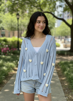 Pe26,17mars Veste à boutons en tricot bleu ciel. Coeurs blanc et col en V